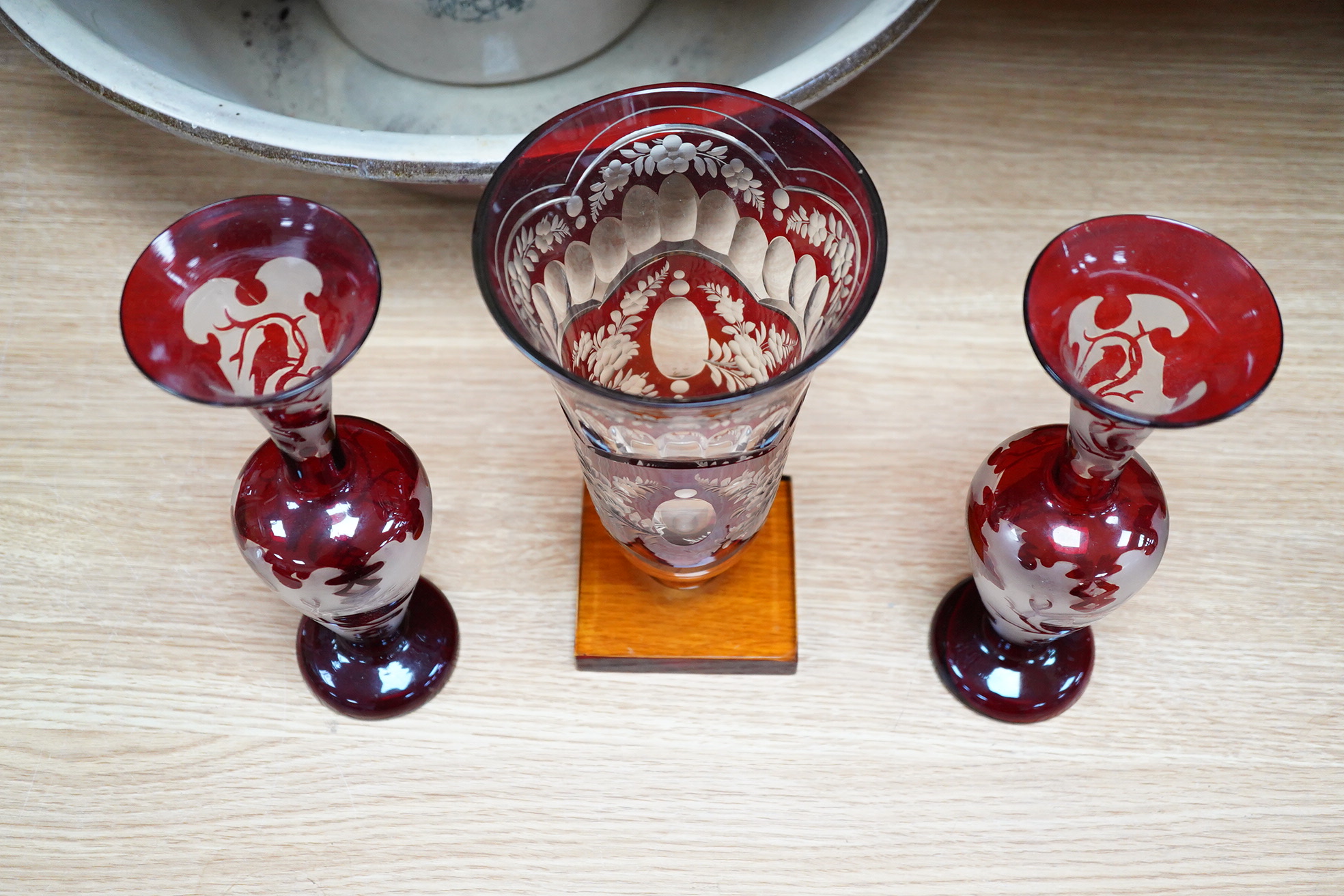 A Czechoslovakian red and amber cut glass square base vase, 21cm high and a pair of similar vases